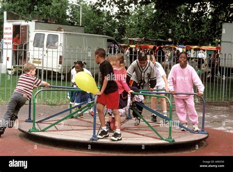 children playing on playground roundabout Stock Photo: 591184 - Alamy