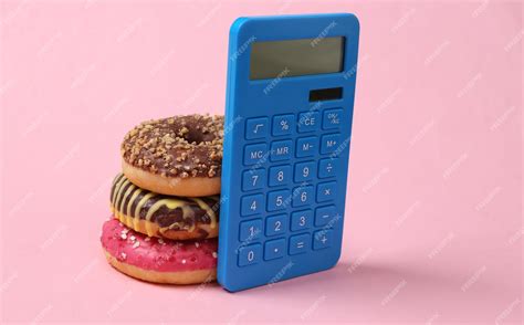 Premium Photo | Calorie counting calculator and high calorie donuts on pink background