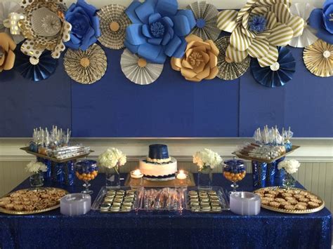 Royal blue and gold dessert table with paper flowers and fan as ...