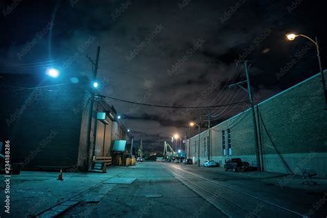 Industrial urban street city night scene with vintage factory warehouses and train tracks Stock ...