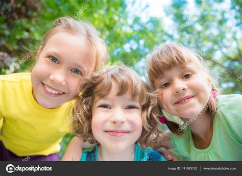 Happy children playing outdoors Stock Photo by ©Yaruta 141883132