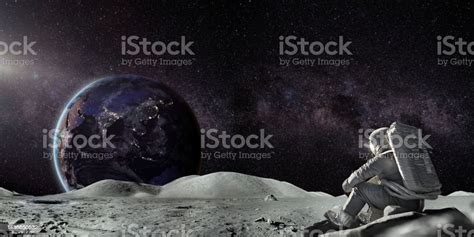 Astronaut Sitting In Contemplation On Moon Looking At Distant Earth ...