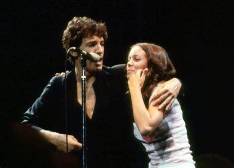 a man and woman standing next to each other in front of a microphone on ...