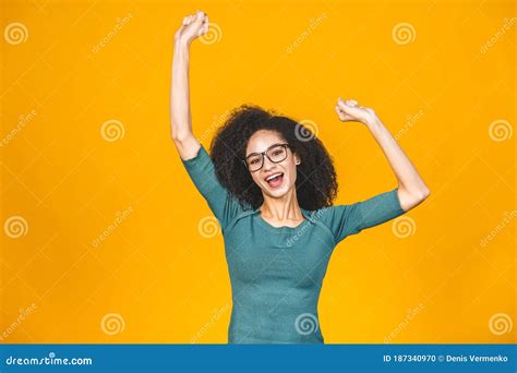 Portrait of a Happy Young African American Black Woman Celebrating Success Isolated Over Yellow ...