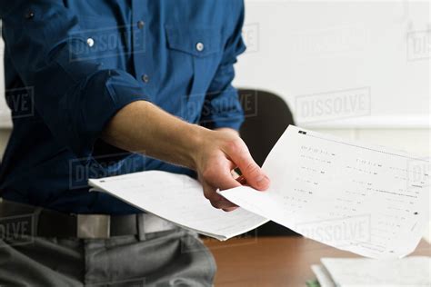 Teacher handing out classwork assignment - Stock Photo - Dissolve