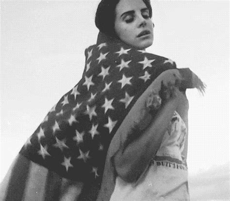 a black and white photo of a woman wrapped up in an american flag shawl