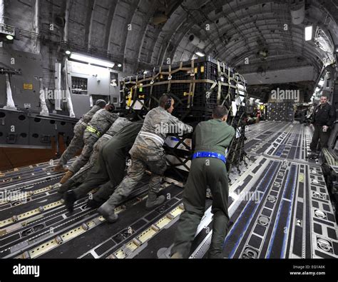 U.S. Air Force Airmen load a pallet onto a U.S. Air Force C-17A Globemaster III cargo aircraft ...