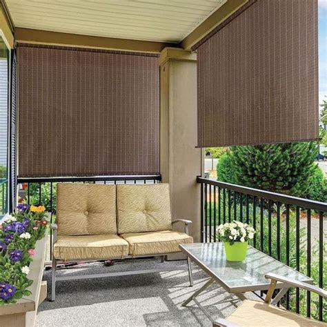 a balcony with two couches and a table on the outside patio, covered in blinds