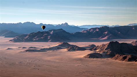 Aerial view with hot air balloon over rocky mountains, Namib-Naukluft National Park, Namibia ...