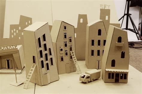 several cardboard buildings are shown on a table