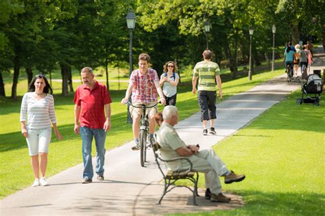 People Walking In Park Stock Photo - Download Image Now - Public Park, Cycling, Walking - iStock