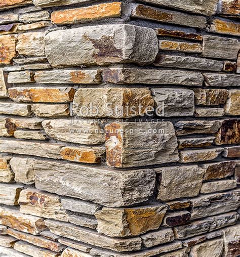 Schist stone wall corner, schist rock layered into decorative wall with mortar. Red schist from ...