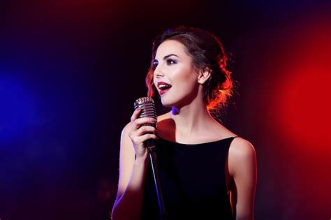 Premium Photo | Portrait of beautiful singing woman on dark background