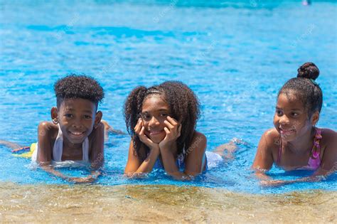 Premium Photo | Group of black children happy playing water pool park outdoor in hot summer season