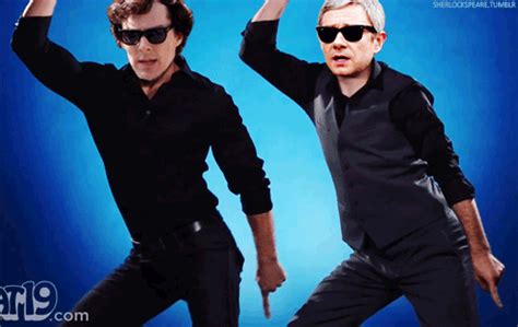 two men in black shirts and sunglasses are dancing