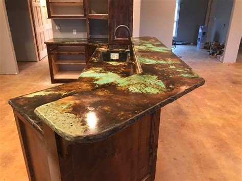 an old kitchen counter with green paint on it's top and wooden cabinets in the background