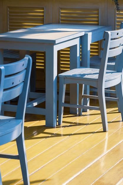 Premium Photo | Dining table set on yellow wooden floor in terrace area of retro coffee shop in ...