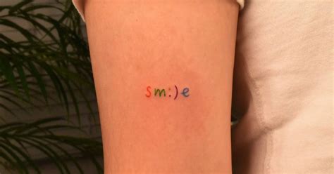 Colorful tattoo of the word "smile" a little smiley