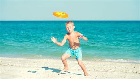 A Child is Playing with a Frisbee on the Beach. Stock Image - Image of ...