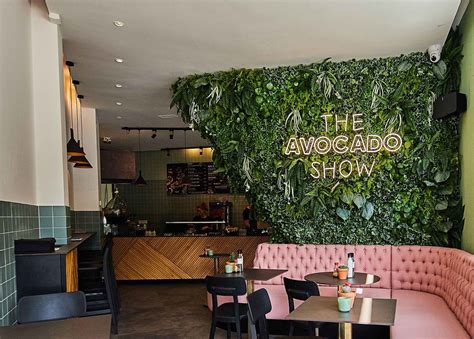 the avocado show restaurant is decorated with greenery and pink velvet ...