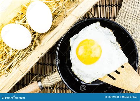 Fried Egg on a Wooden Spatula Over a Frying Pan. Stock Image - Image of breakfast, black: 114971231