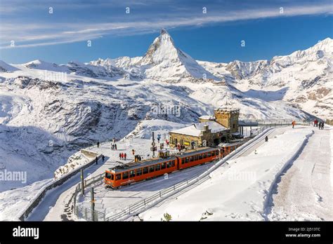 Gornergrat, Zermatt, Switzerland - November 12, 2019: Red cable car train on snowy railway at ...