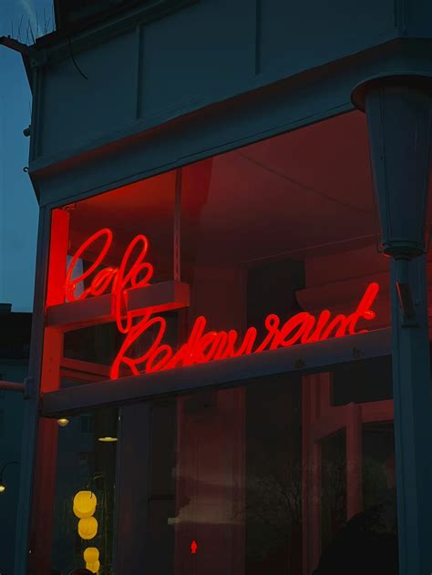 A red neon sign on the side of a building photo – Free Innere stadt ...