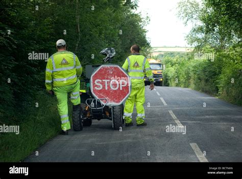 STOP,stop sign for workmen in luminous clothes to top dress a road in the Teign Valley Devon ...