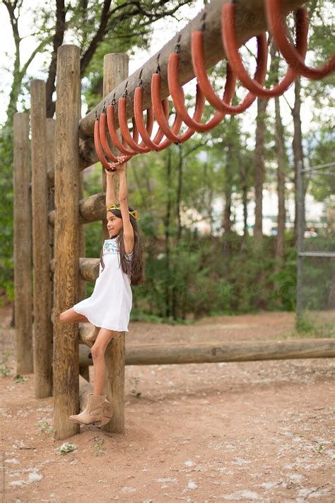 "Young Girl Swinging On Monkey Bars" by Stocksy Contributor "Gabrielle Lutze" - Stocksy