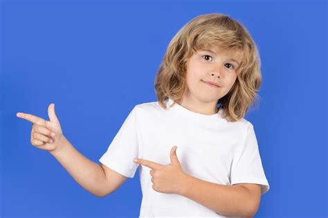 Premium Photo | Kid pointing finger on isolated studio background kid pointing to copyspace ...