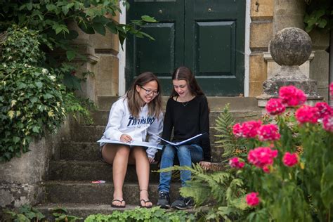 two-female-students-sat-on-steps-outdoors