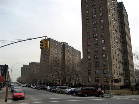 cars are parked on the side of the road in front of tall buildings and traffic lights