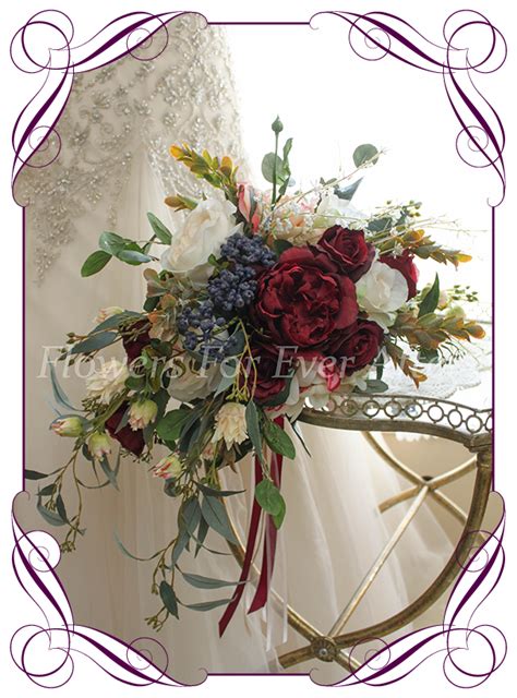 a bridal bouquet with red and white flowers on a metal stand in front ...