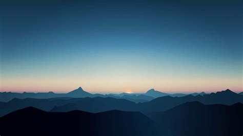 Download A Mountain Range At Sunset With Mountains In The Background Wallpaper | Wallpapers.com