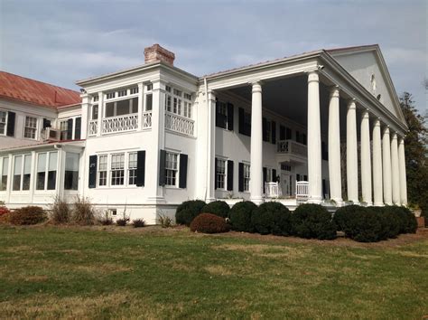 a large white house with columns on the front and side of it's roof