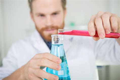 Scientist Pouring Liquid into Flask Stock Image - Image of blurredperson, reagent: 265787291