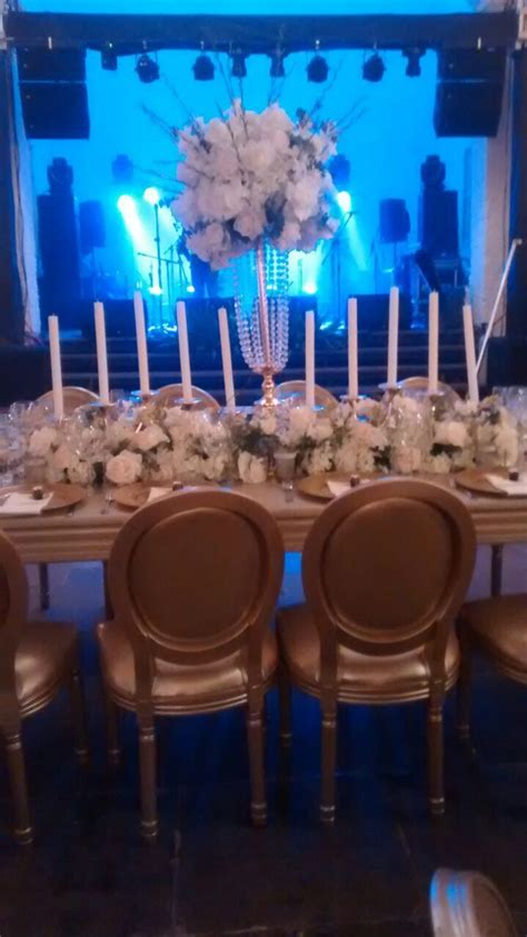 a table set up with candles and flowers on it for a formal dinner or party