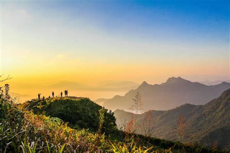 Photo of People Standing on Top of Mountain Near Grasses Facing Mountains during Golden Hours ...