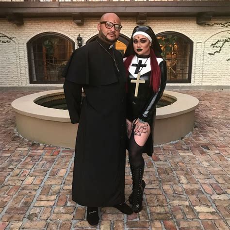 a man and woman dressed up as nun and nunette standing in front of a fountain