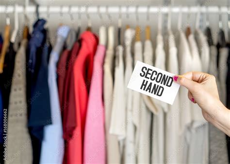 Second hand clothing shop. Used clothes hanging in hanger in a rack and ...