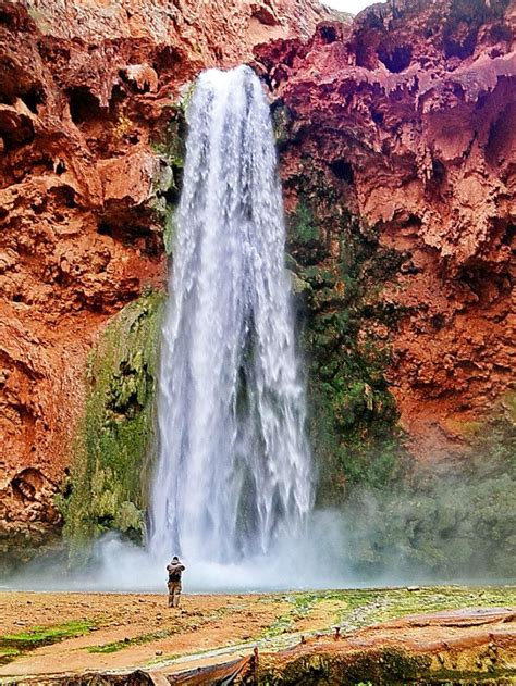 a man standing in front of a waterfall