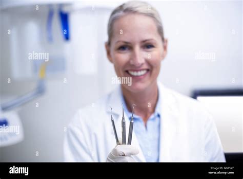 Female dentist holding dental tools Stock Photo - Alamy