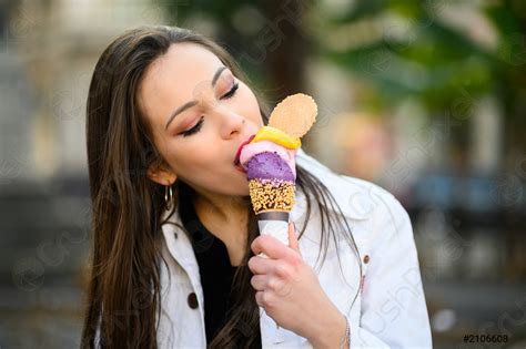 Attractive girl eating ice cream on the city street - stock photo ...