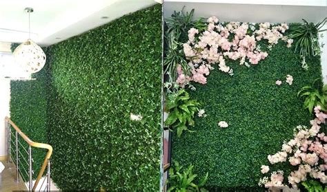 the wall is covered with artificial plants and pink flowers, which are growing on it