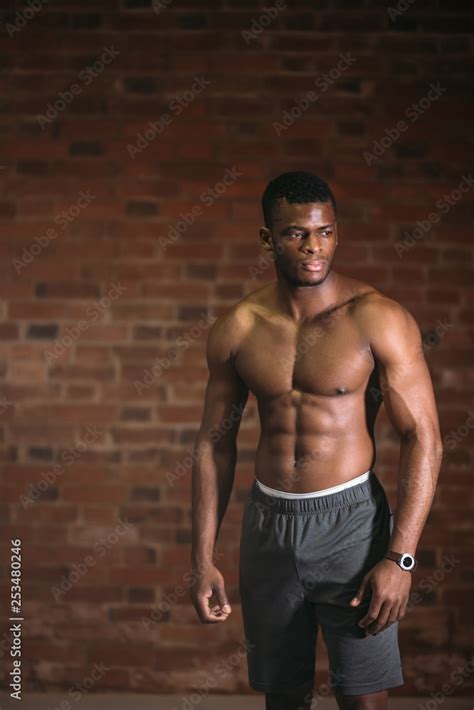 Strong afroamerican athletic man with naked perfect shape muscular body looking at camera ...