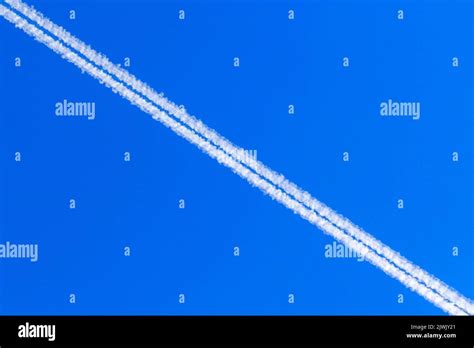 Jet vapour trials against a blue sky background Stock Photo - Alamy