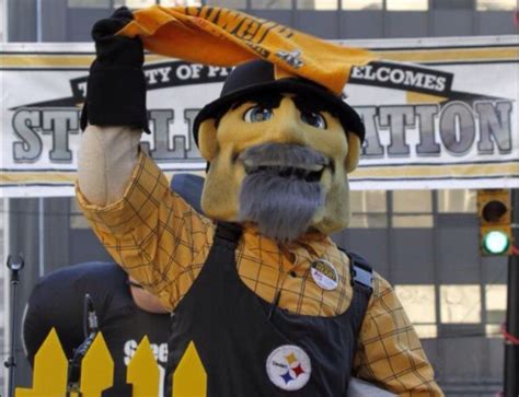 a man dressed in an orange and black outfit holding up a yellow scarf over his head