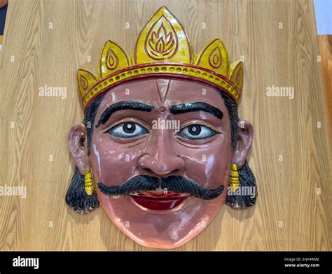 Handmade colorful tribal look of Ravan face mask souvenir hanging on plain black background ...