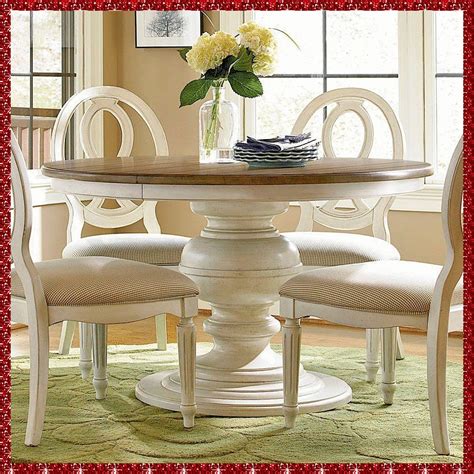 a dining room table with chairs and a vase filled with flowers on top of it