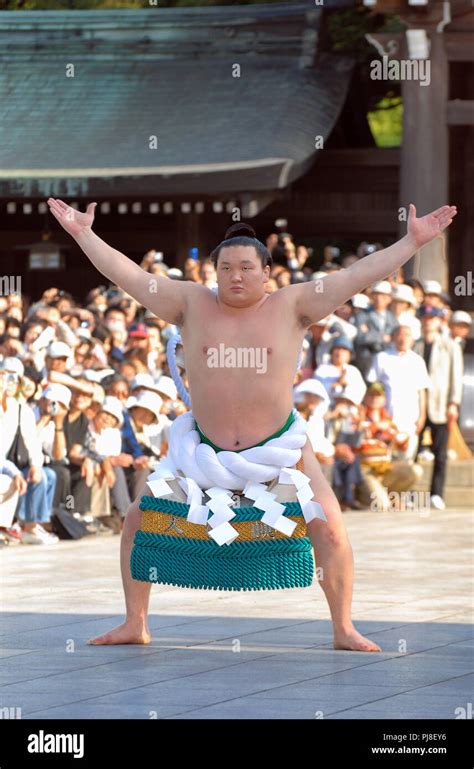 Mongolian sumo wrestler Hakuho, wearing a grand champion's ceremonial rope belt, performs a ...